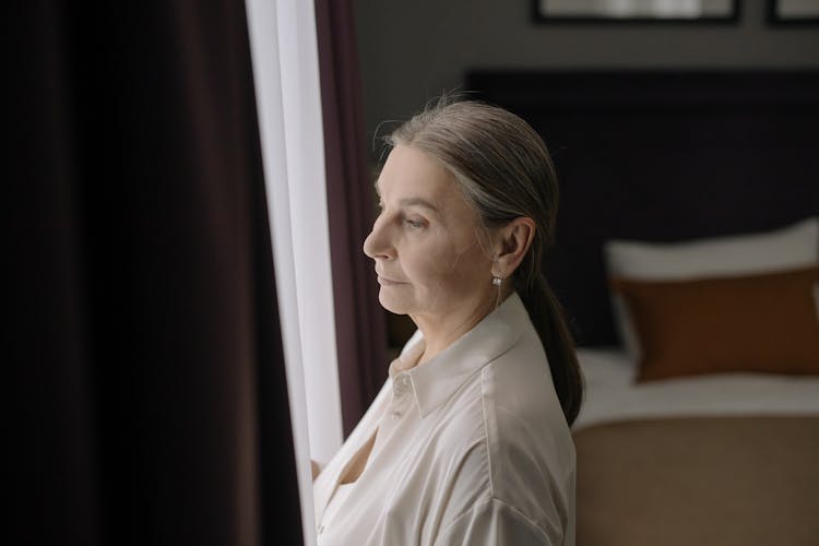 Elderly Woman Standing By The Window