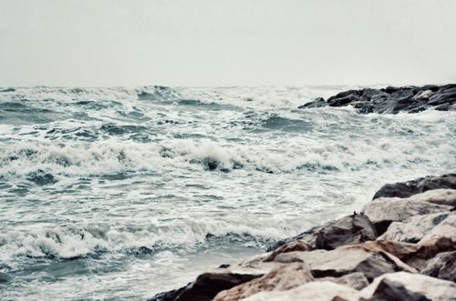 Free Dramatic ocean waves crashing against a rocky shore, capturing nature's untamed power. Stock Photo