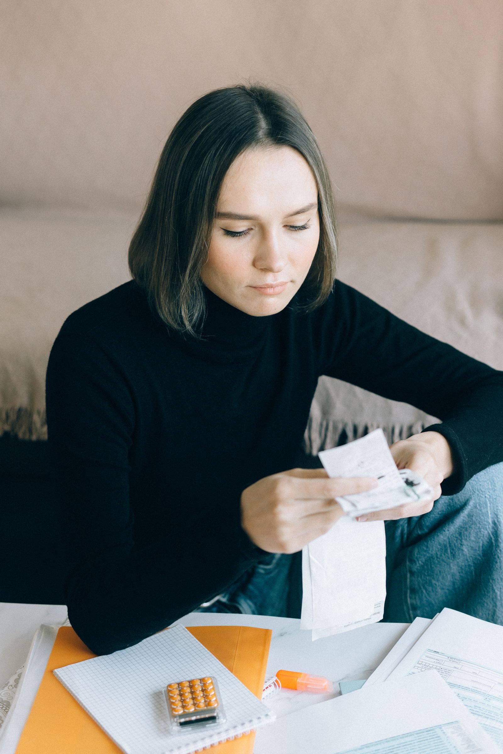 Woman using a calculator to review bills and documents