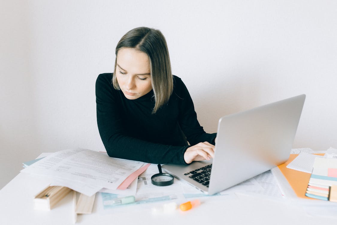 Woman in Black Long Sleeve Shirt Using Macbook Air 