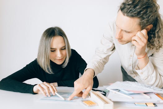 Two colleagues collaborating on a project, focusing on documents and teamwork in a modern office setting.