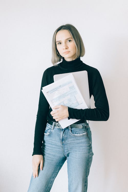 Woman in Black Long Sleeve Shirt Holding Tax Forms