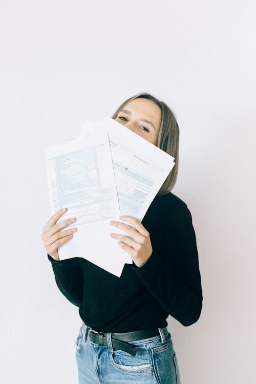 Free Woman In Black Shirt With Gray Hair Holding Tax Forms Stock Photo