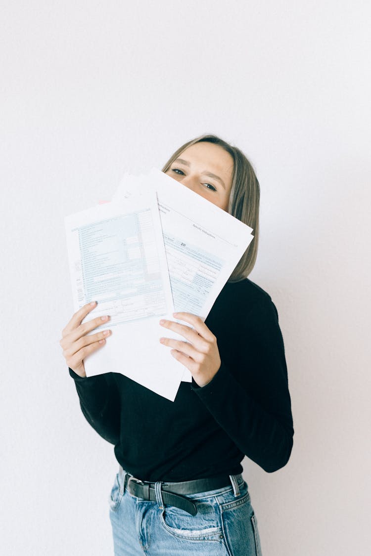 Woman In Black Shirt With Gray Hair Holding Tax Forms