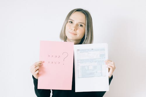 Free Woman Holding A Pink Paper Offering Service On Tax Forms Stock Photo