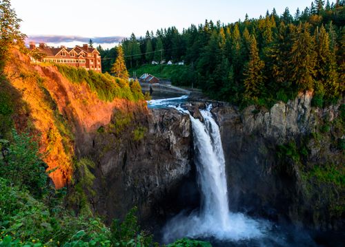 Free Breathtaking view of Snoqualmie Falls with vibrant sunset hues and lush greenery. Stock Photo
