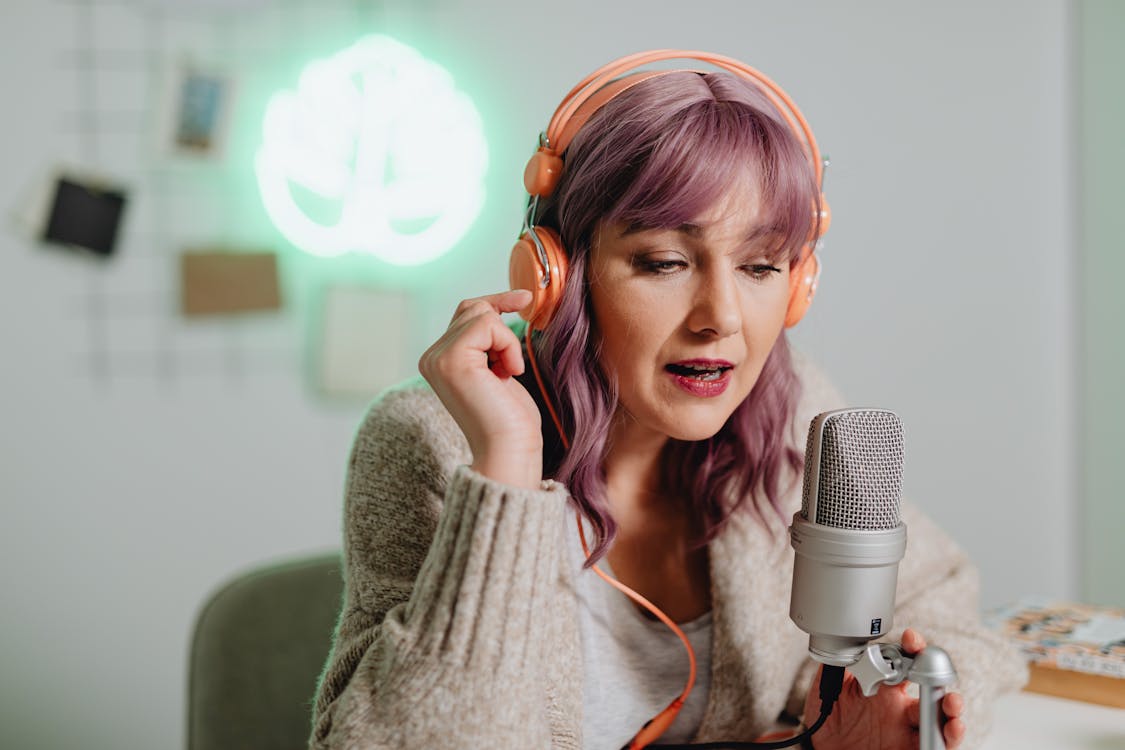 Free A Woman Talking on a Microphone while Wearing a Headphone Stock Photo