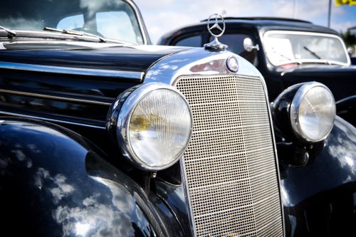 Free Close-up of a vintage black Mercedes Benz car showcasing its classic style and shiny headlights. Stock Photo