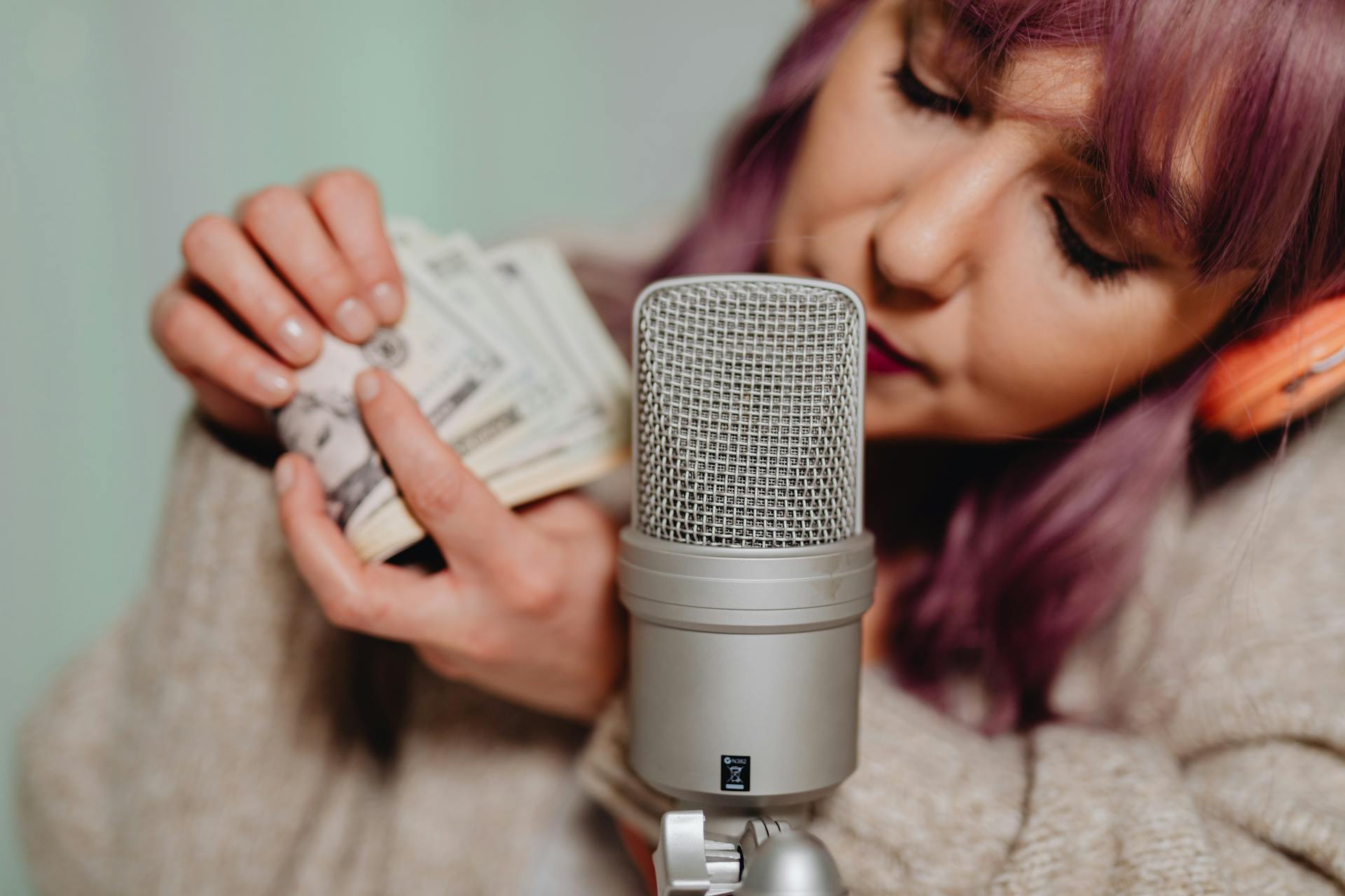 A Woman in Gray Sweater Holding Bank Notes