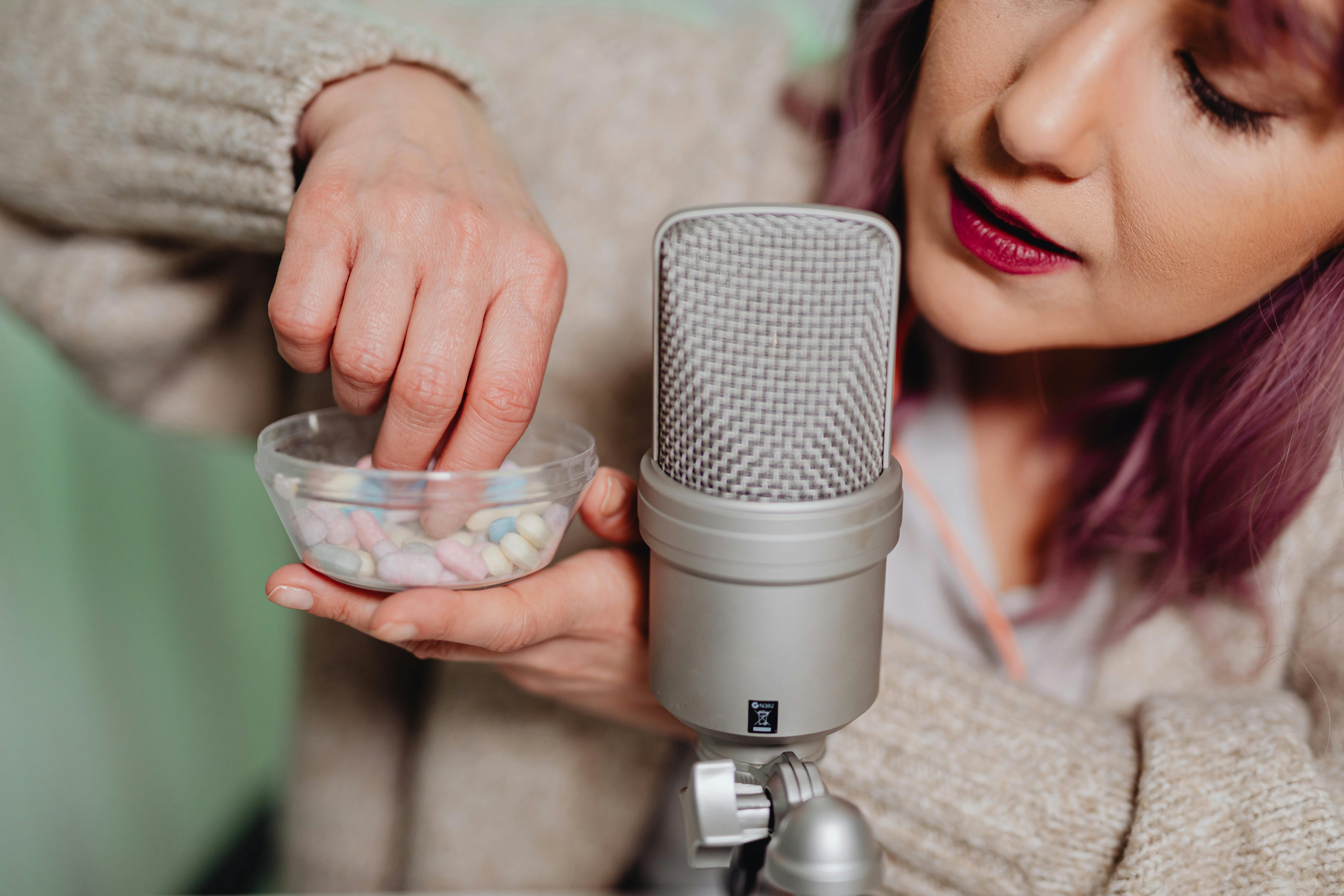 a woman holding a cup of capsules