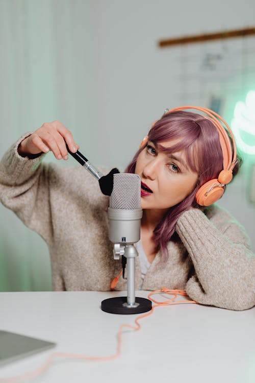 A Woman Brushing and Talking on a Microphone