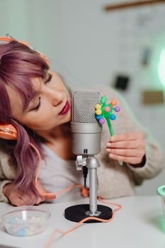 Relaxing ASMR session with a woman using a microphone indoors.