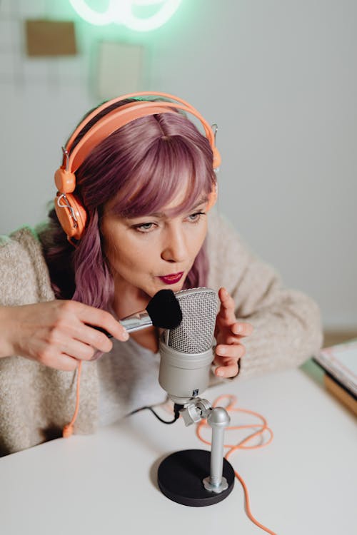 A Woman Brushing and Talking on a Microphone