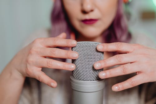 Free A Woman Touching a Microphone Stock Photo