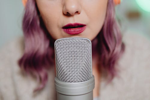 Free A Woman Talking on a Microphone Stock Photo