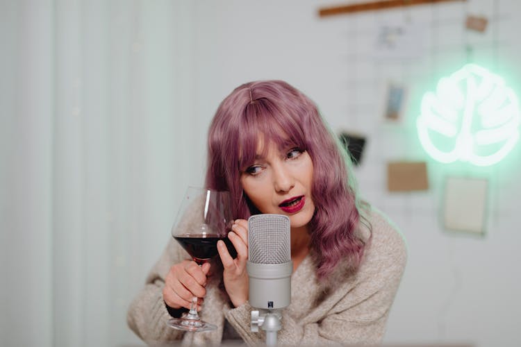 A Woman Holding A Glass Of Wine