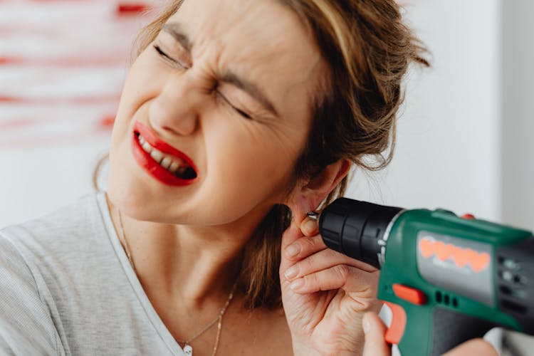 A Woman Holding Green And Black Cordless Power Drill