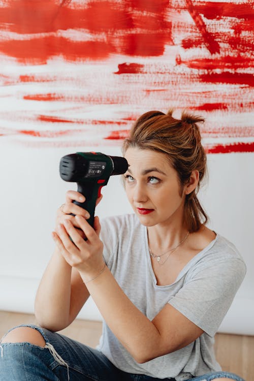 Free A Woman Holding a Power Tool Stock Photo