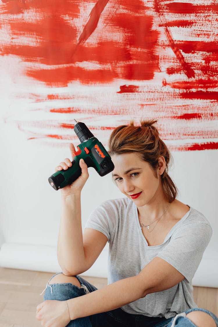 A Woman Holding Green And Black Cordless Power Drill