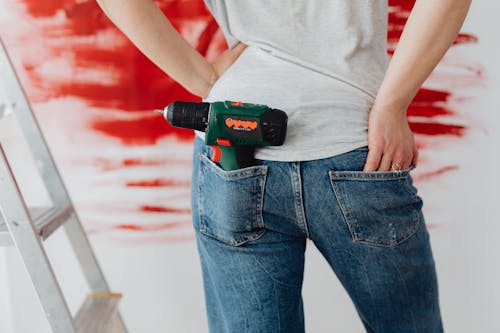 Free A Woman in Denim Jeans With a Hand Drill Stock Photo