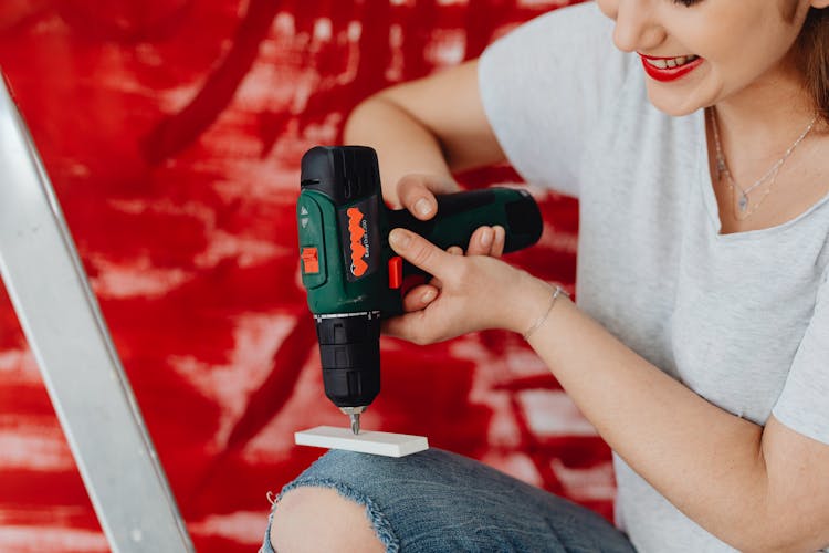 Woman Smiling And Using An Automatic Screwdriver 