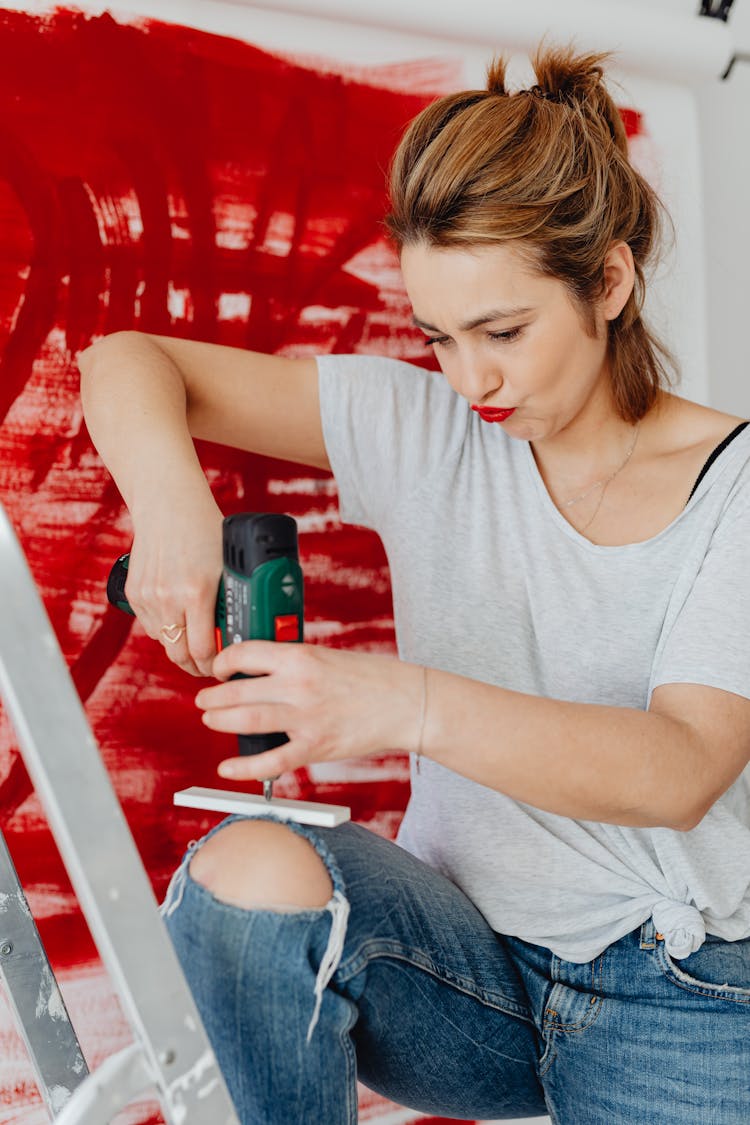 Woman Drilling A Piece Of Wood