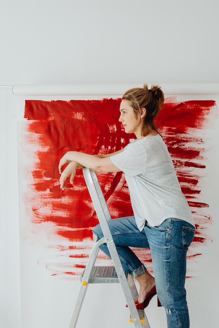 Woman Climbing On Folding Step Ladder