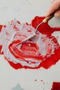 Person Holding White and Red Paint Brush