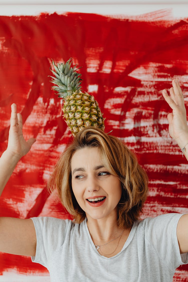 Woman Balancing A Pineapple On Her Head