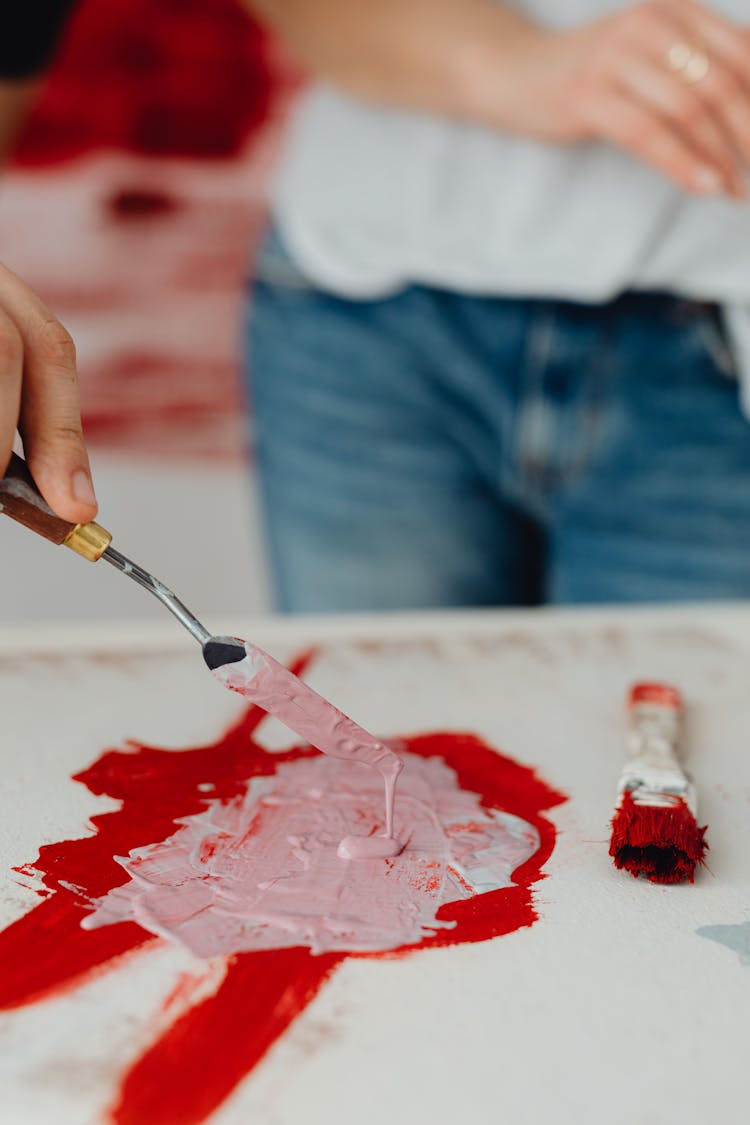 Woman Mixing Paints With A Paintbrush 