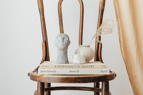 White Figurine, Vase and Books on Wooden Chair