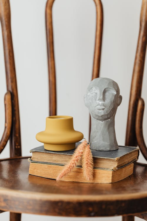 Figurine and Books on Wooden Chair