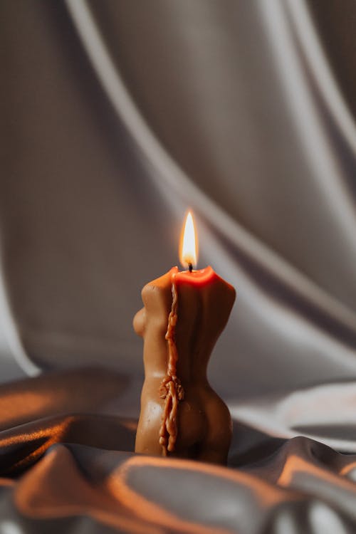 Lighted Candle in Gray Cloth