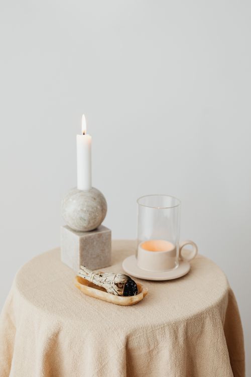 Free A serene still life with candles and sage on a natural tablecloth for a calming ambiance. Stock Photo