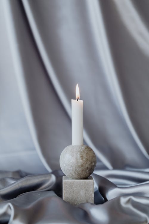 White Candle and Stone Ball and Cube on Silk