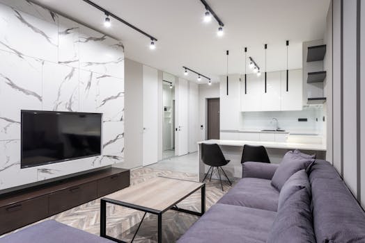 Stylish open-plan living room and kitchen with modern design elements and marble accents.