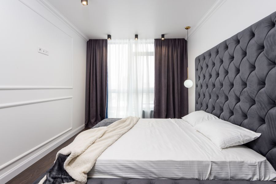 Belle chambre d'hôtel avec rideaux, voilages et tête de lit capitonnée