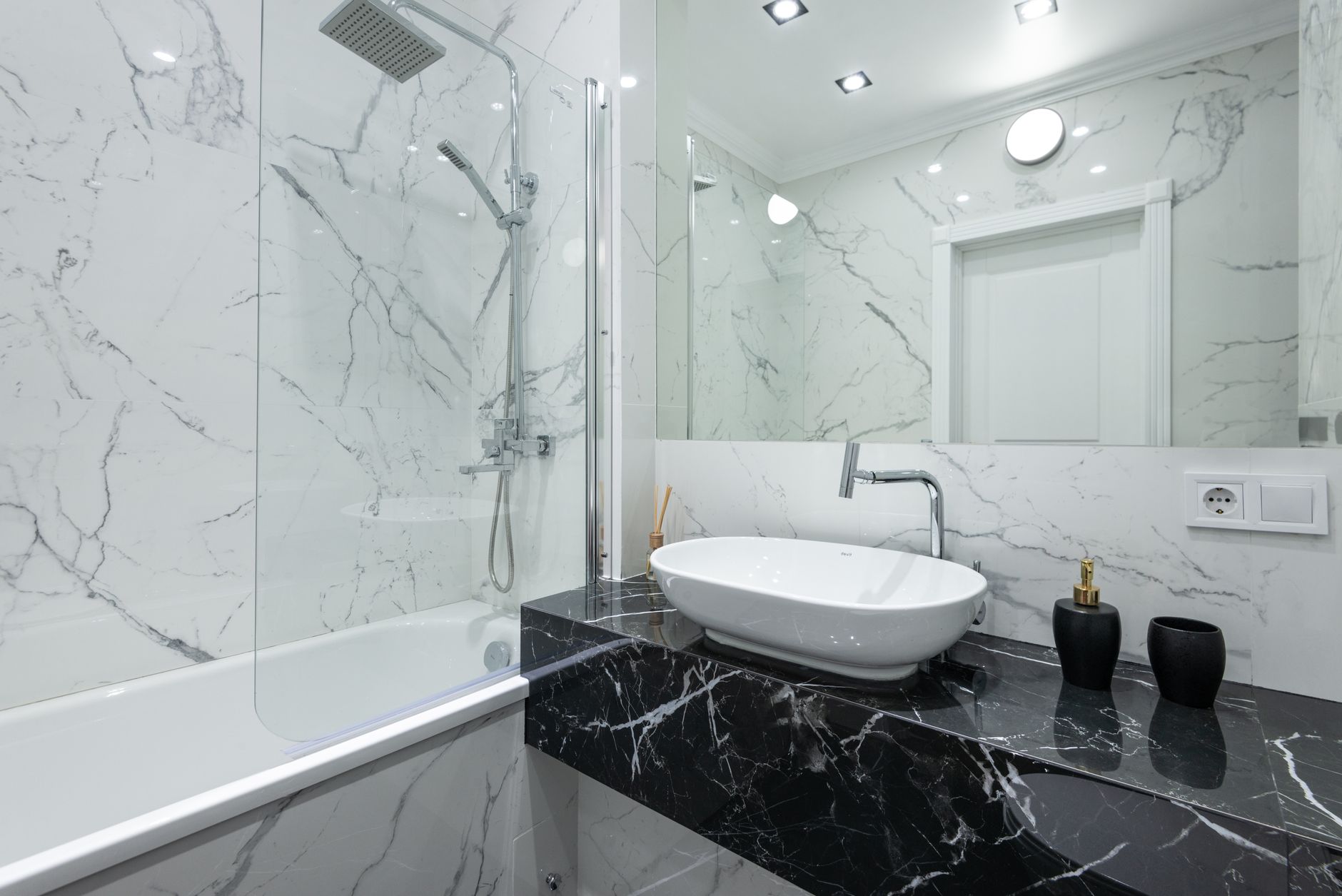 Harvey Baker Plumbing, Inc - Luxurious bathroom featuring marble walls, a vessel sink, and contemporary fixtures.
