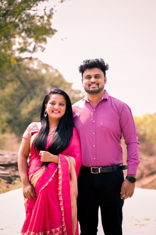 Free A happy couple in traditional Indian clothing standing outdoors on a bright day. Stock Photo