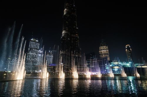 Free Illuminated Dubai skyline featuring Burj Khalifa and fountains at night. Stock Photo