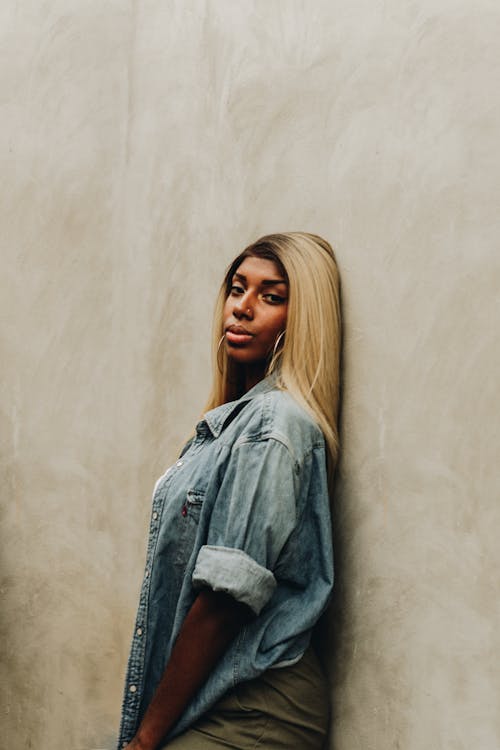 Woman in Blue Denim Jacket Leaning on Wall