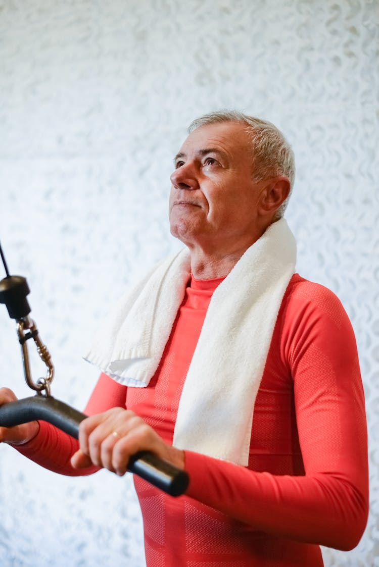 An Elderly Man Pulling A Gym Equipment While Looking Up