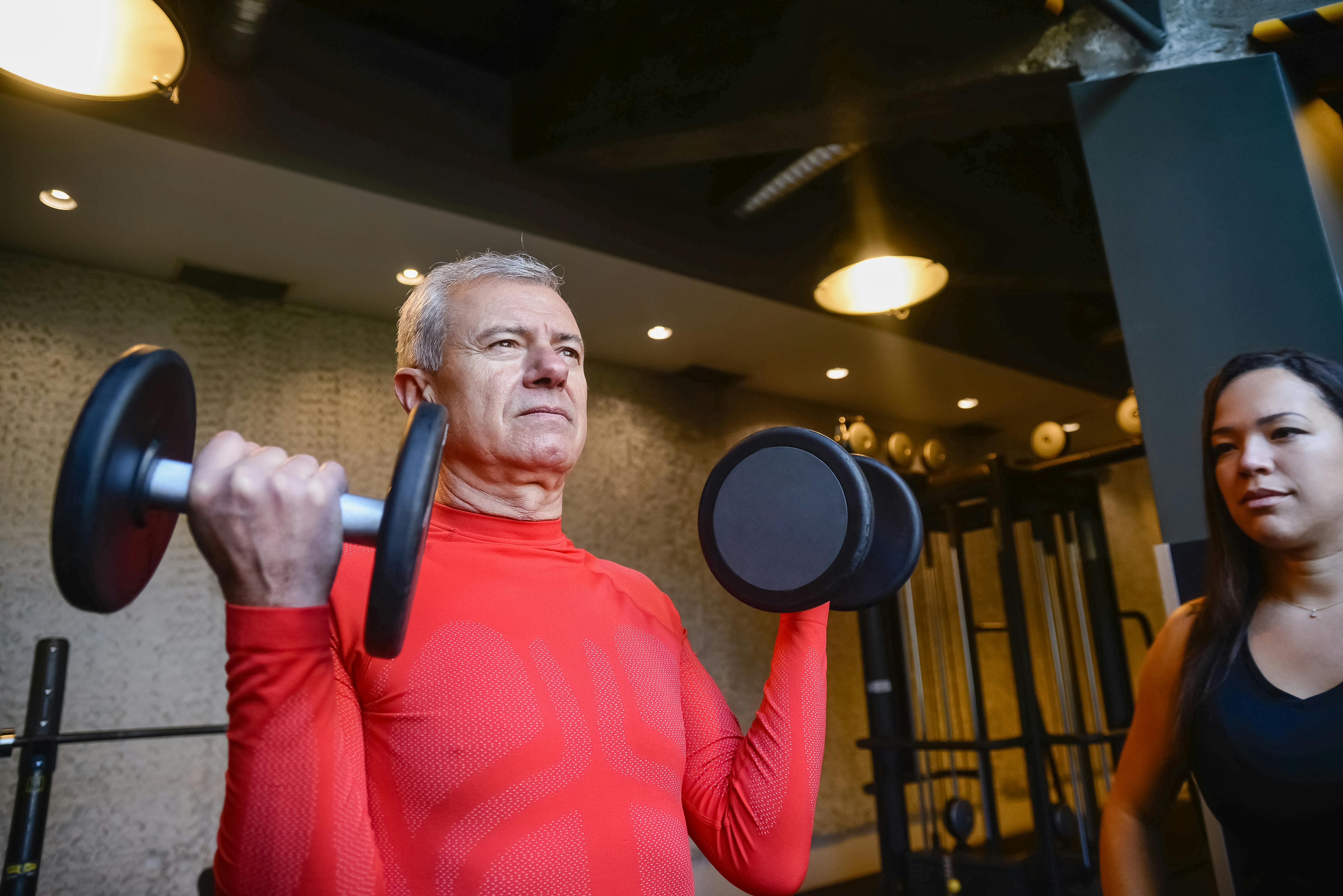 patient atteint d'un AVC qui participe activement en faisant de renforcment musculaire avec un kiné à domicile.