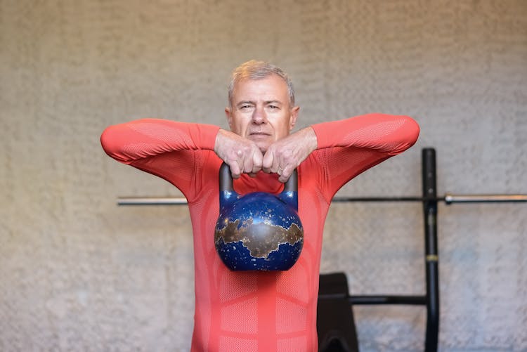 Elderly Man Lifting A Heavy Kettlebell