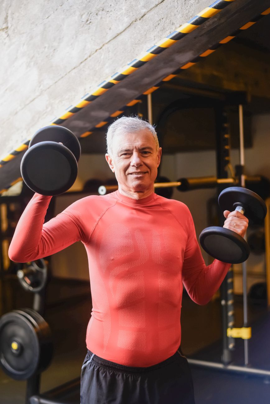 Senior man lifting dumbbells during a gym session