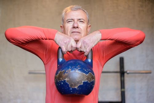 Elderly Man Lifting a Heavy Kettlebell