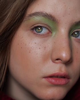 Detailed close-up shot of a face with green eyeshadow, highlighting natural beauty.