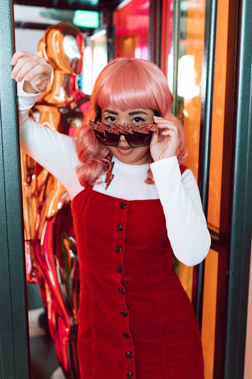 Woman in Red Jumper and White Long Sleeve Shirt Wearing Black Sunglasses