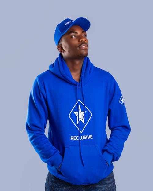 Confident black man wearing hoodie and cap in studio