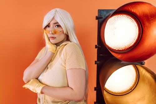 A Woman in a Mesh Shirt Posing Near a Large Stoplight